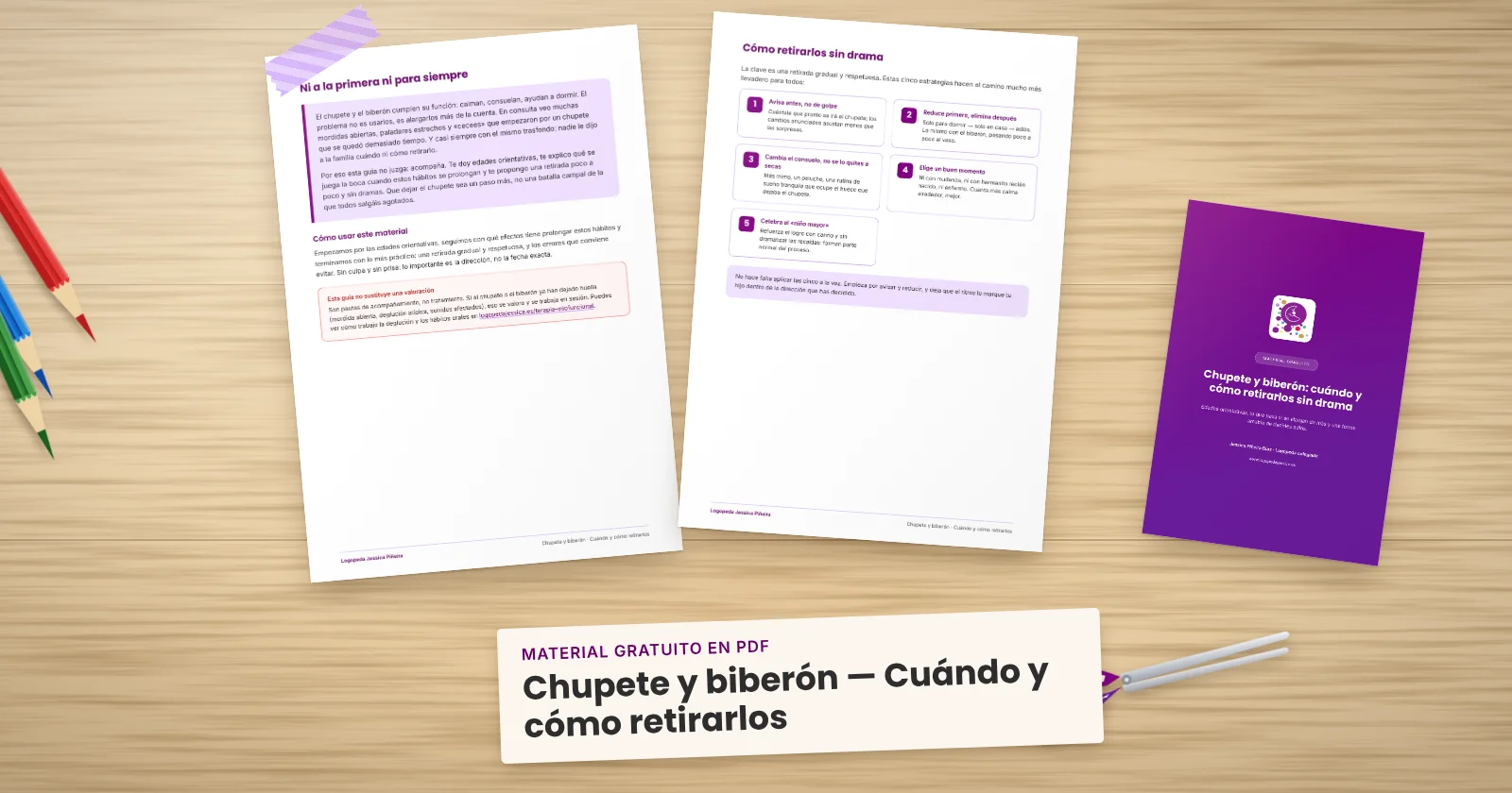 Dos páginas impresas de «Chupete y biberón — Cuándo y cómo retirarlos» sujetas con cinta washi sobre una mesa de madera, con la portada asomando. Alrededor, una etiqueta de papel con el título, lápices de colores y unas tijeras.