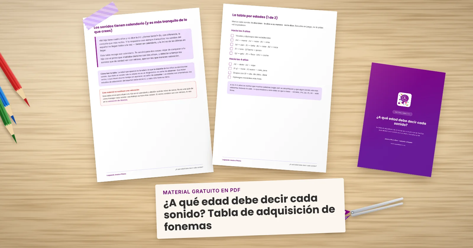 Dos páginas impresas de «¿A qué edad debe decir cada sonido? Tabla de adquisición de fonemas» sujetas con cinta washi sobre una mesa de madera, con la portada asomando. Alrededor, una etiqueta de papel con el título, lápices de colores y unas tijeras.