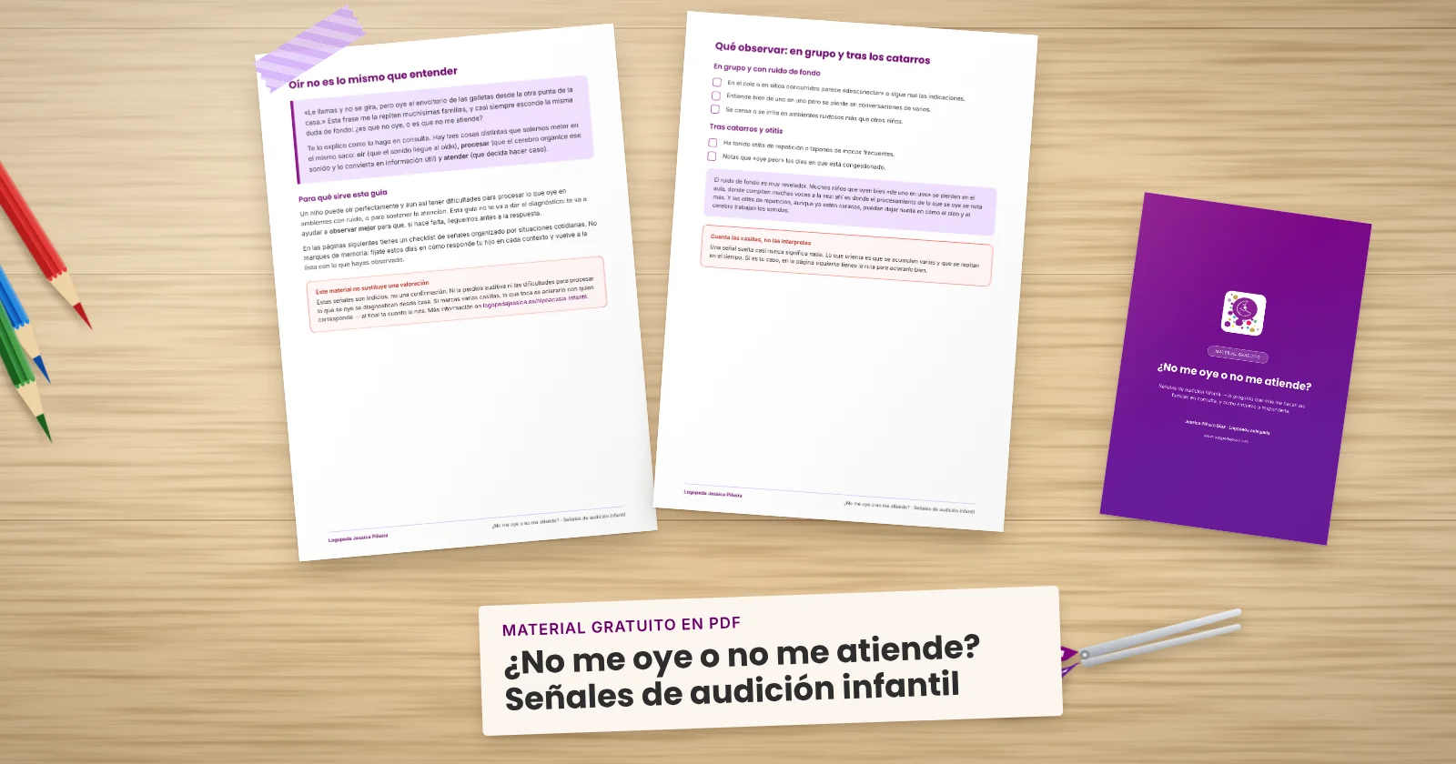 Dos páginas impresas de «¿No me oye o no me atiende? Señales de audición infantil» sujetas con cinta washi sobre una mesa de madera, con la portada asomando. Alrededor, una etiqueta de papel con el título, lápices de colores y unas tijeras.